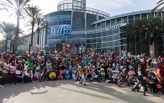 Op de promotieafbeelding voor BlizzCon staan een fantasiekrijger, een tovenares, een gepantserde soldaat en een futuristische strijder afgebeeld, waarmee de spanning van het gamen wordt benadrukt. Links staat in opvallende letters “BlizzCon”